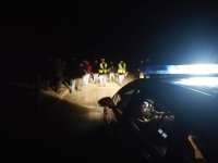 Policjanci oraz osoby uczestniczące w eksperymencie w świetle reflektorów samochodu