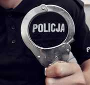 kajdanki i napis policja na koszulce policjanta