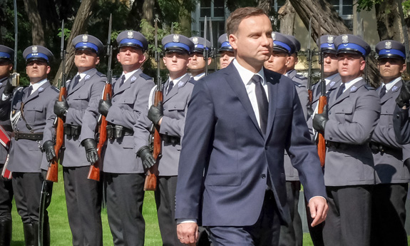 Prezydent Andrzej Duda, w tle policjanci