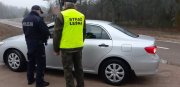 policjant wraz ze strażnikiem leśnym kontroluje srebrny samochód