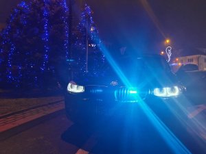 policyjny radiowóz nieoznakowany z włączonymi światłami uprzywilejowania