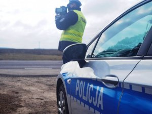 policjant mierzy prędkość na drodze
