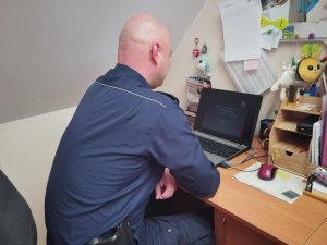 policjant prowadzi zajęcia online