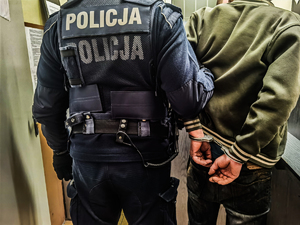 policjant trzyma zatrzymanego mężczyznę