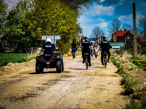 policjanci na quadach i rowerach zabezpieczają rajd rowerowy