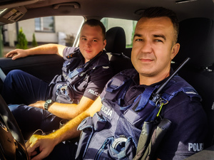 dwóch policjantów siedzi w pojeździe