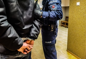 policjanci trzymają zatrzymanego mężczyznę