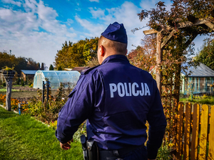 policjant rozmawia z działkowcami