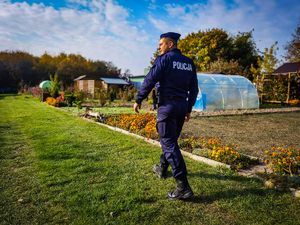 policjant rozmawia z działkowcami