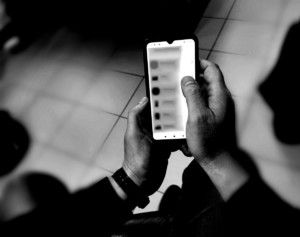 W rękach trzymany jest telefon komórkowy