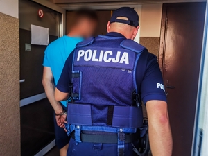 policjant prowadzi zatrzymanego mężczyznę