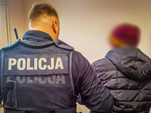 policjant, obok stoi zatrzymany mężczyzna